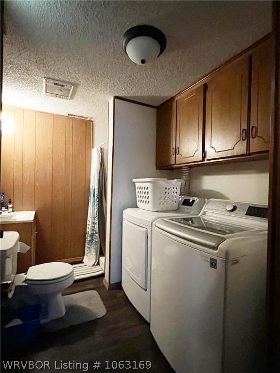 washroom featuring independent washer and dryer, a textured ceiling, and dark hardwood / wood-style flooring