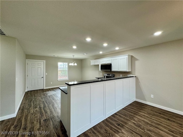 kitchen featuring white cabinetry, dark wood-type flooring, a notable chandelier, kitchen peninsula, and pendant lighting