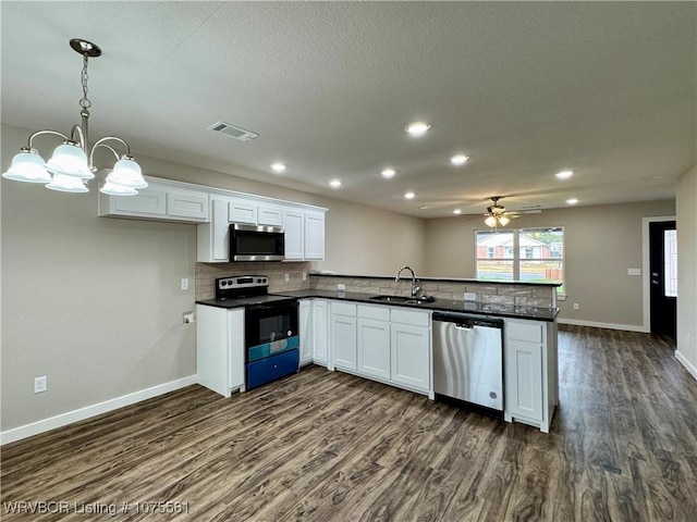 kitchen with white cabinets, sink, hanging light fixtures, and appliances with stainless steel finishes