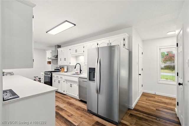 9010 Skypark Dr, Fort Smith, AR 72903 - kitchen with appliances with stainless steel finishes, a sink, light countertops, wall chimney exhaust hood, and white cabinets