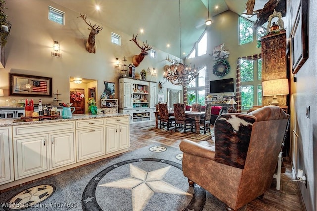 living room featuring hardwood / wood-style floors, a high ceiling, and a chandelier