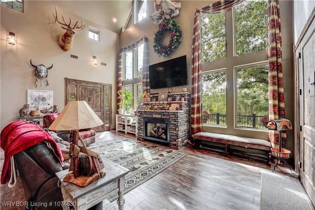 living room featuring a fireplace, hardwood / wood-style floors, and high vaulted ceiling