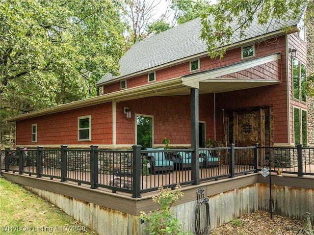 rear view of property featuring a wooden deck