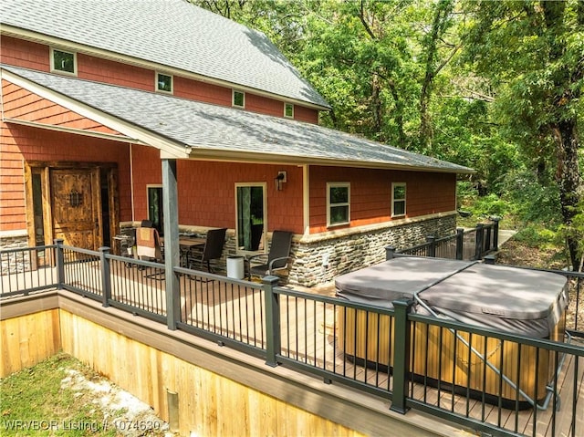 back of property featuring a hot tub