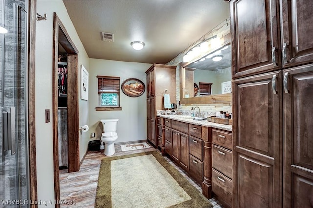 bathroom with hardwood / wood-style floors, vanity, and toilet