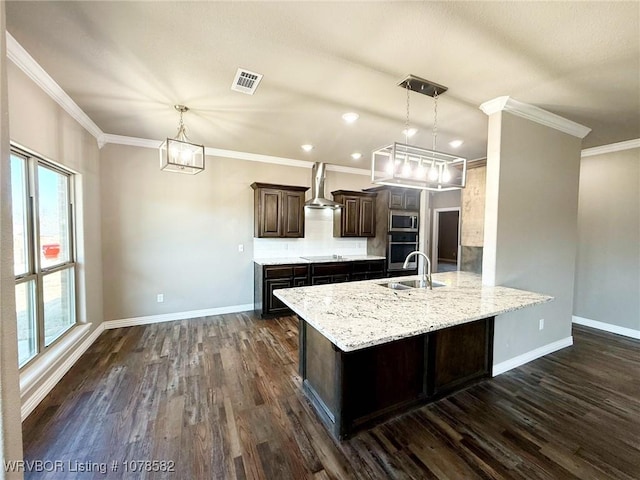 kitchen featuring sink, hanging light fixtures, kitchen peninsula, dark brown cabinets, and wall chimney exhaust hood