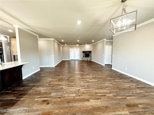 unfurnished living room featuring ceiling fan with notable chandelier, ornamental molding, and hardwood / wood-style flooring