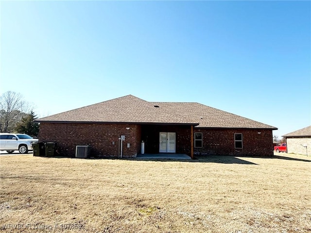 rear view of property featuring central AC and a yard