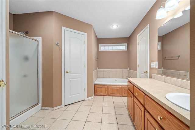 bathroom with tile patterned flooring, vanity, baseboards, a bath, and a stall shower