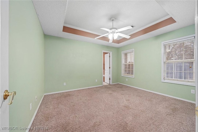 spare room with baseboards, a raised ceiling, and a textured ceiling