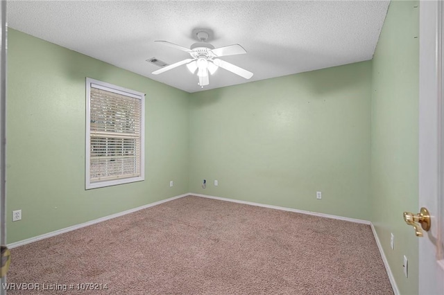 spare room with carpet, ceiling fan, baseboards, and a textured ceiling