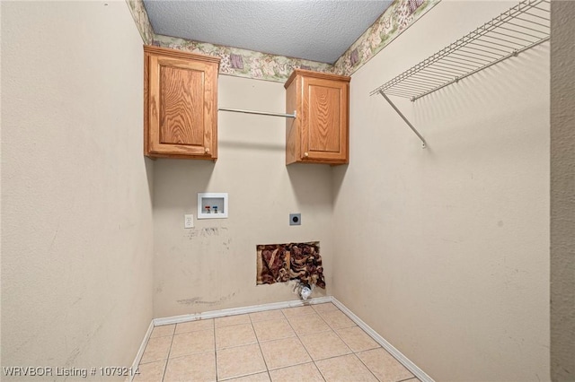 washroom with a textured ceiling, hookup for a washing machine, baseboards, cabinet space, and electric dryer hookup