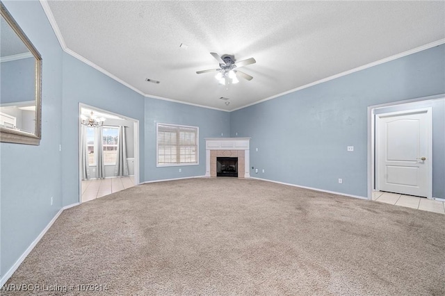 unfurnished living room featuring carpet, crown molding, a fireplace, a textured ceiling, and ceiling fan with notable chandelier