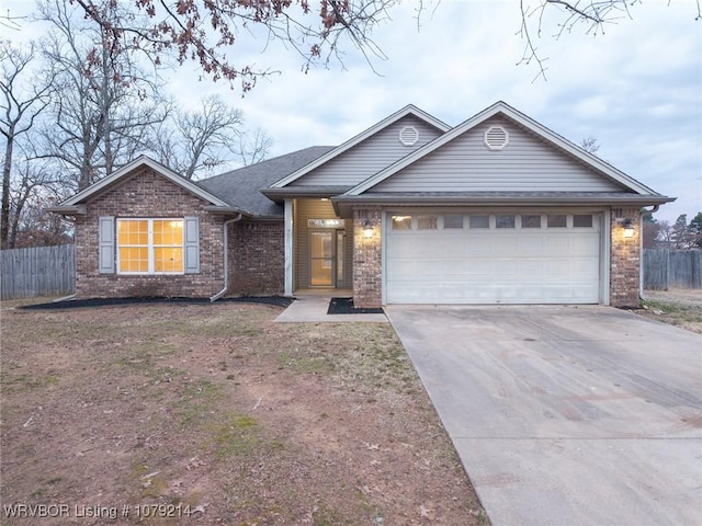 ranch-style home featuring an attached garage, fence, concrete driveway, and brick siding