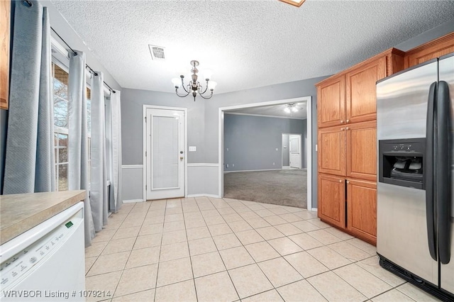 kitchen with light tile patterned floors, visible vents, stainless steel fridge with ice dispenser, an inviting chandelier, and white dishwasher