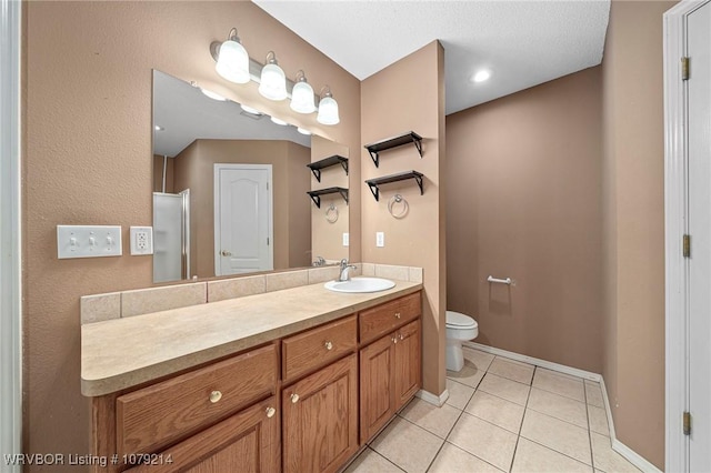 bathroom with toilet, tile patterned flooring, baseboards, and vanity