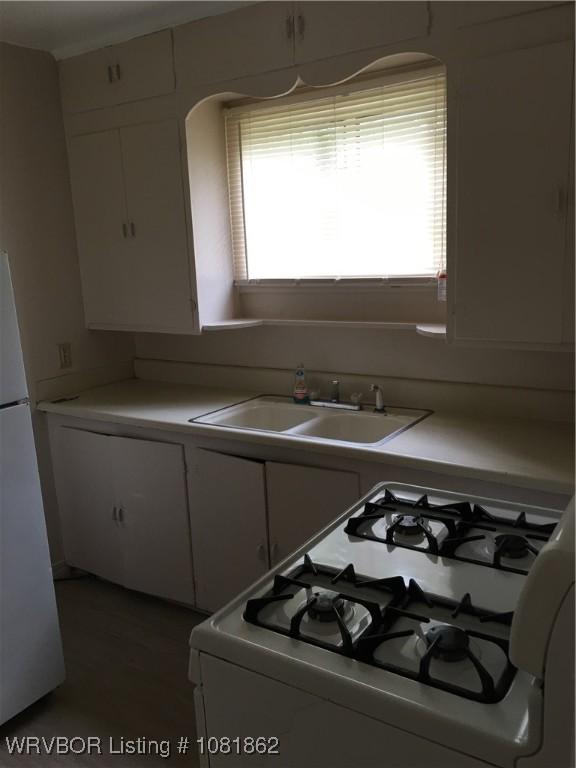 1101 N 6th St Unit A & B, Fort Smith, AR 72901 - kitchen with white appliances, white cabinets, light countertops, and arched walkways