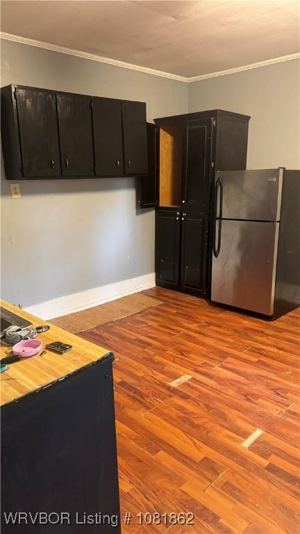 1101 N 6th St Unit A & B, Fort Smith, AR 72901 - kitchen with freestanding refrigerator, dark cabinetry, light wood-type flooring, and crown molding