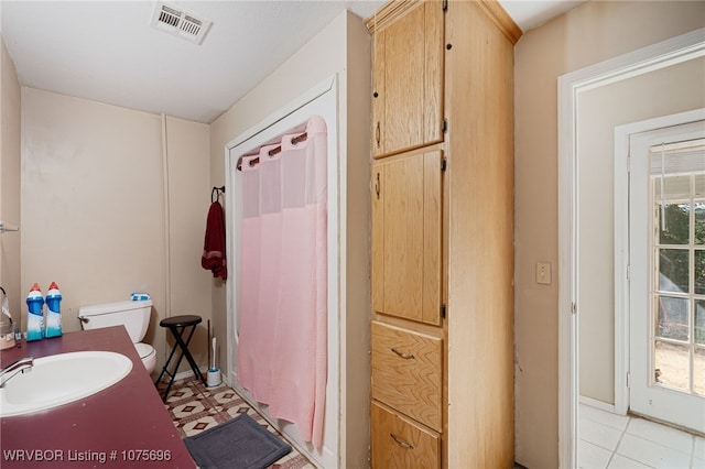 bathroom featuring tile patterned floors, a shower with curtain, toilet, and sink