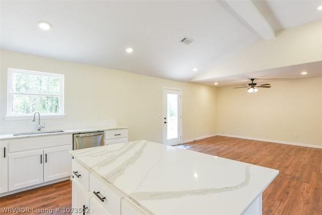 kitchen featuring ceiling fan, dishwasher, sink, a kitchen island, and white cabinets