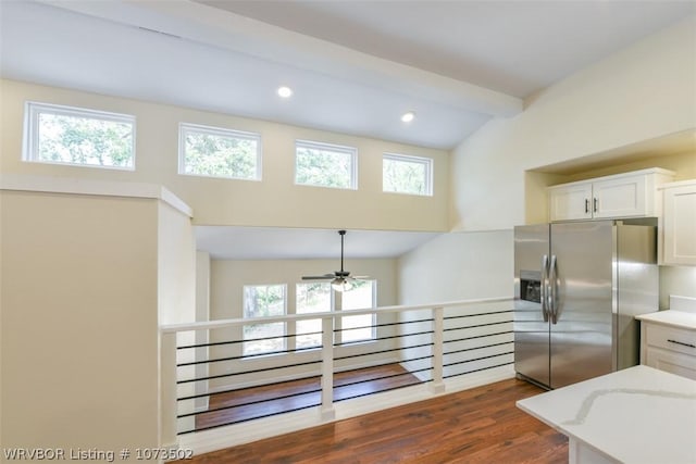 kitchen featuring beam ceiling, white cabinetry, a wealth of natural light, ceiling fan, and stainless steel fridge