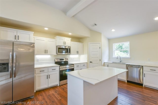 kitchen with a center island, stainless steel appliances, white cabinetry, and sink