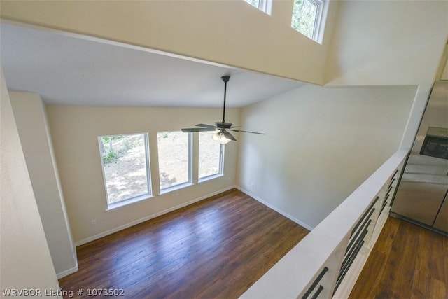 unfurnished living room featuring ceiling fan and dark hardwood / wood-style flooring