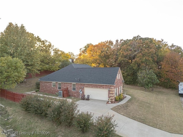 view of side of home featuring a yard, cooling unit, and a garage