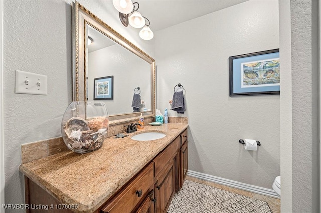 bathroom with tile patterned flooring, vanity, and toilet