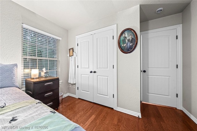 bedroom with dark hardwood / wood-style flooring and a closet