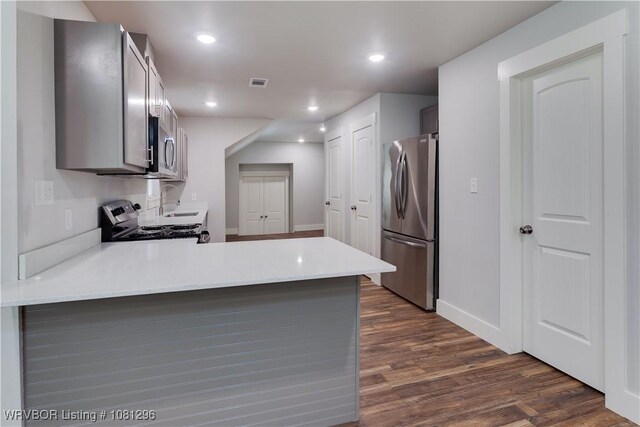 3305 Spradling Ave, Fort Smith, AR 72904 - kitchen with appliances with stainless steel finishes, dark wood-type flooring, a peninsula, light countertops, and baseboards