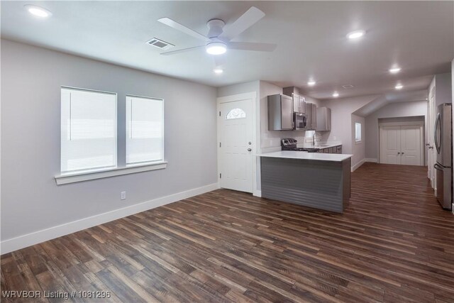 3305 Spradling Ave, Fort Smith, AR 72904 - kitchen featuring appliances with stainless steel finishes, ceiling fan, baseboards, dark wood-type flooring, and a peninsula