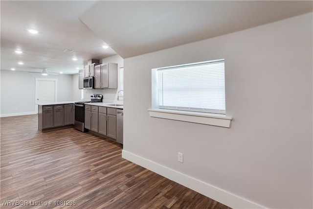 3305 Spradling Ave, Fort Smith, AR 72904 - kitchen with stainless steel appliances, gray cabinets, a peninsula, baseboards, and dark wood-type flooring