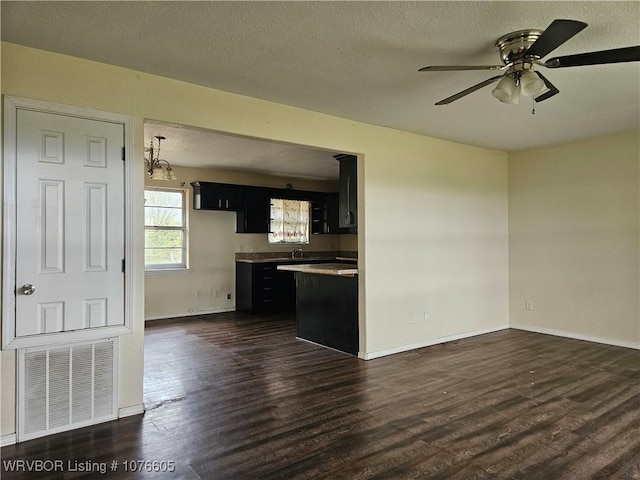 interior space featuring ceiling fan, dark hardwood / wood-style floors, and a textured ceiling