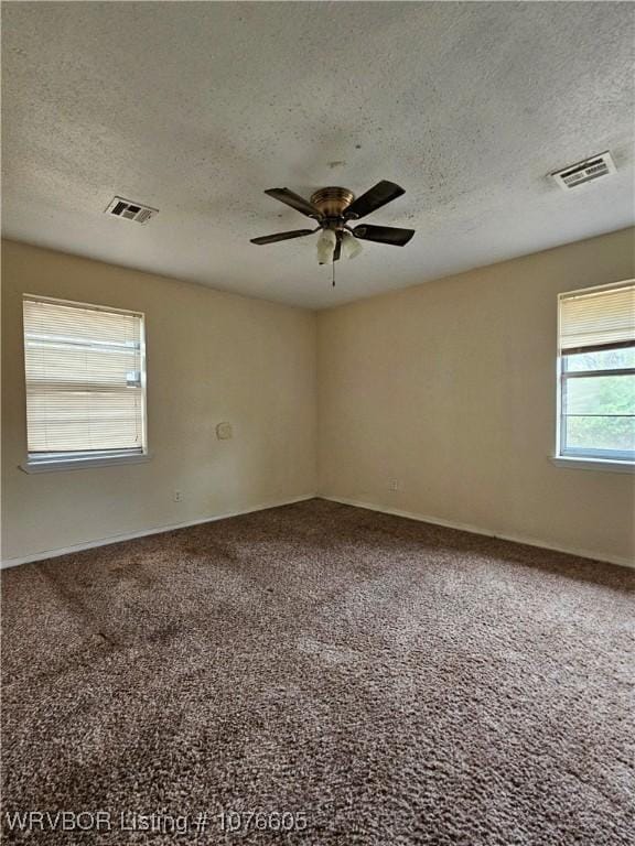 unfurnished room with ceiling fan, carpet, and a textured ceiling