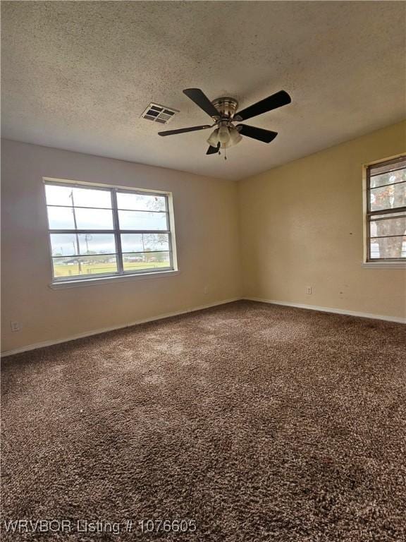 carpeted empty room featuring ceiling fan and a textured ceiling