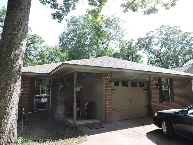 2016-2018 S V St, Fort Smith, AR 72901 - view of home's exterior with a garage, brick siding, driveway, and roof with shingles