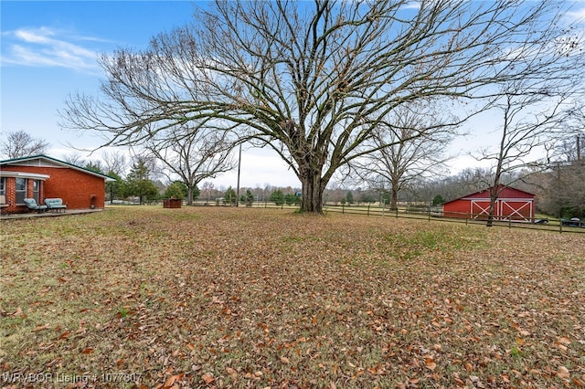 view of yard with a rural view and an outdoor structure