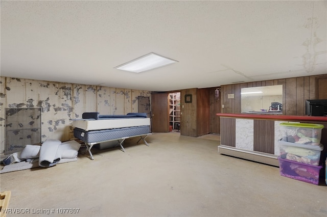 bedroom featuring wood walls and a textured ceiling