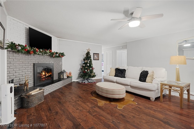 living room with a brick fireplace, ceiling fan, and dark wood-type flooring