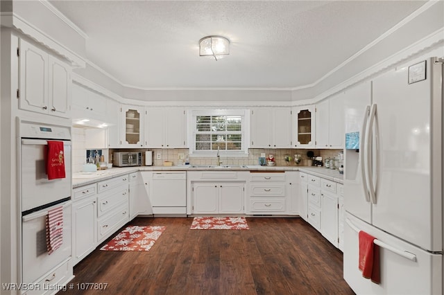 kitchen featuring sink, white cabinets, dark wood-type flooring, and white appliances