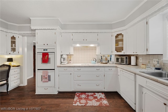 kitchen with decorative backsplash, white appliances, sink, dark hardwood / wood-style floors, and white cabinetry