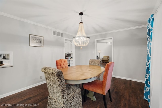 dining space featuring dark hardwood / wood-style floors, an inviting chandelier, and crown molding