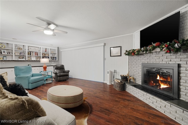 living room with hardwood / wood-style flooring, ceiling fan, a fireplace, and a textured ceiling