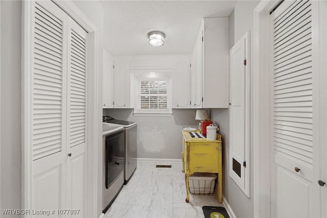 laundry room featuring washer and clothes dryer and cabinets