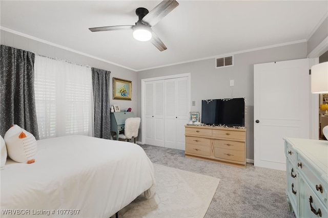 bedroom featuring ceiling fan, ornamental molding, light carpet, and a closet