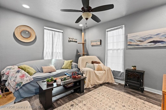 2101 Birnie Ave, Fort Smith, AR 72904 - living room with a wood stove, a textured wall, plenty of natural light, a ceiling fan, and wood finished floors