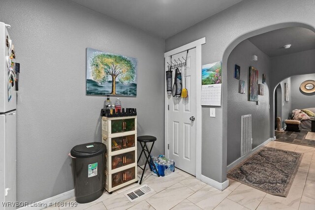 2101 Birnie Ave, Fort Smith, AR 72904 - entrance foyer with arched walkways, marble finish flooring, a textured wall, and baseboards