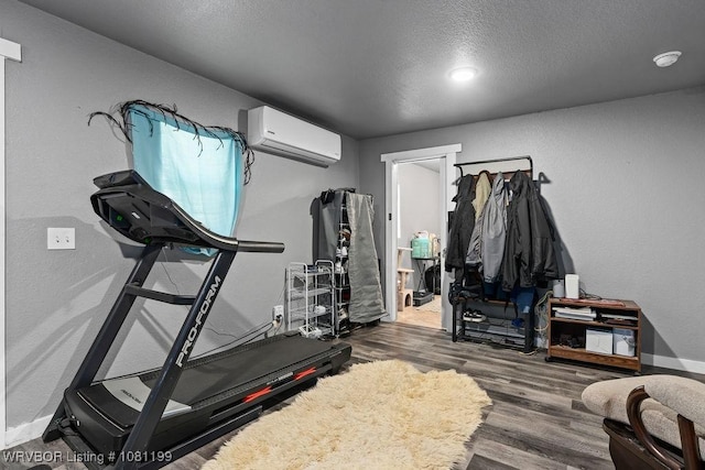 2101 Birnie Ave, Fort Smith, AR 72904 - exercise area with a wall mounted AC, wood finished floors, baseboards, and a textured ceiling