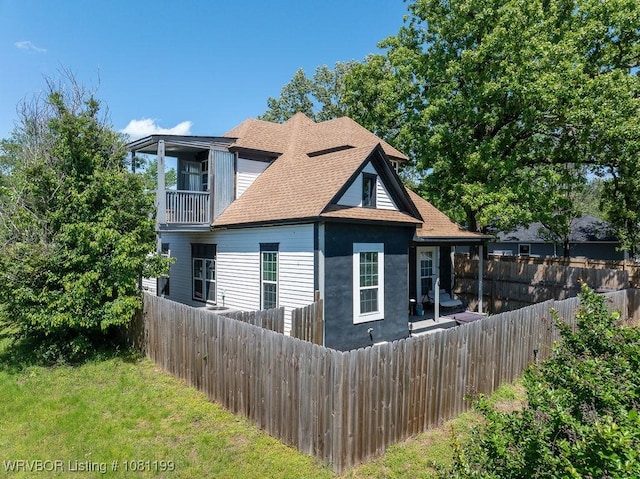 2101 Birnie Ave, Fort Smith, AR 72904 - view of side of property with a fenced backyard, a shingled roof, and a balcony